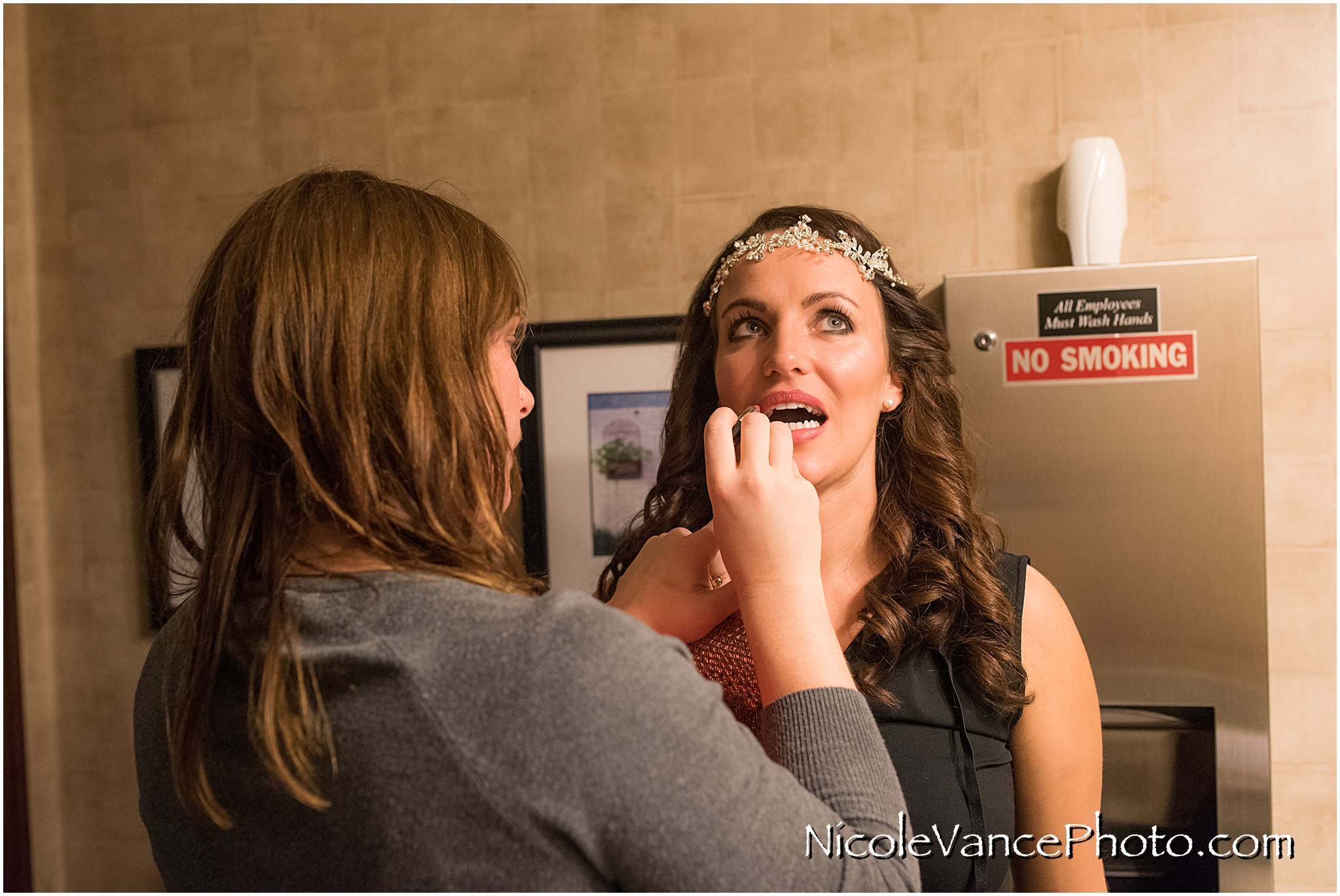 The bride gets last minute touch ups in the bathroom at Bookbinders.