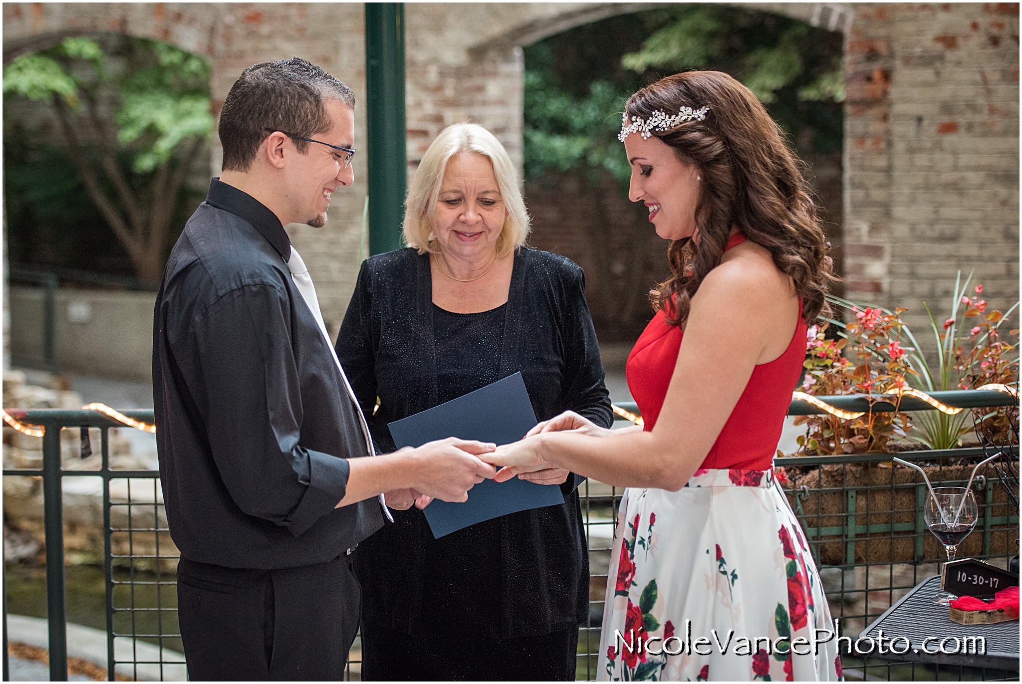 Exchanging rings during their wedding ceremony at Bookbinders on the back patio.