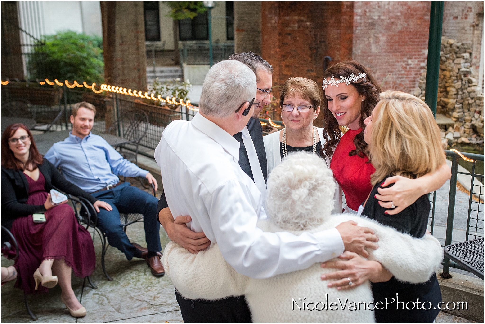The whole family embraces after a wedding ceremony at Bookbinders on the back patio.