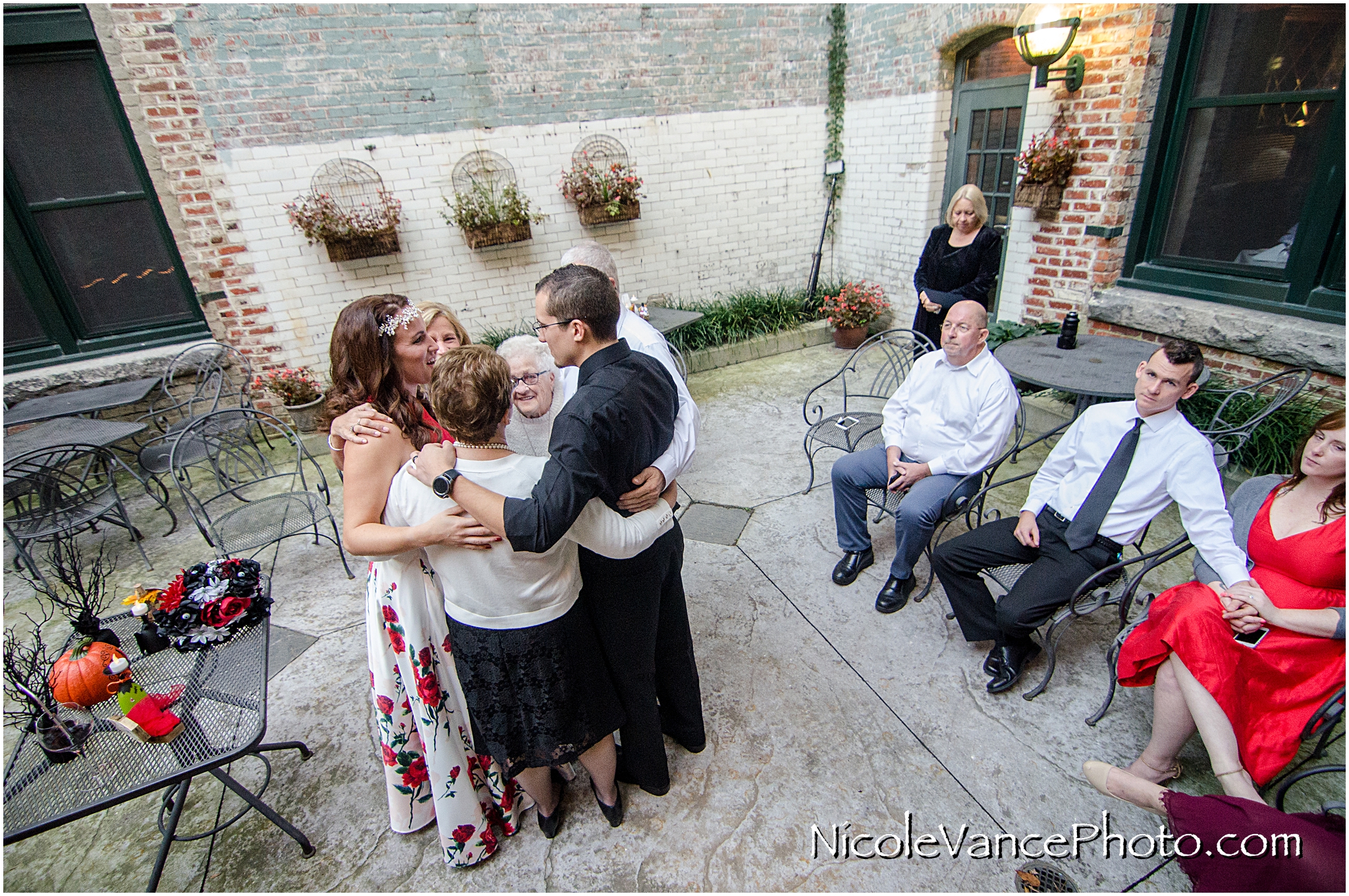 The whole family embraces after a wedding ceremony at Bookbinders on the back patio.