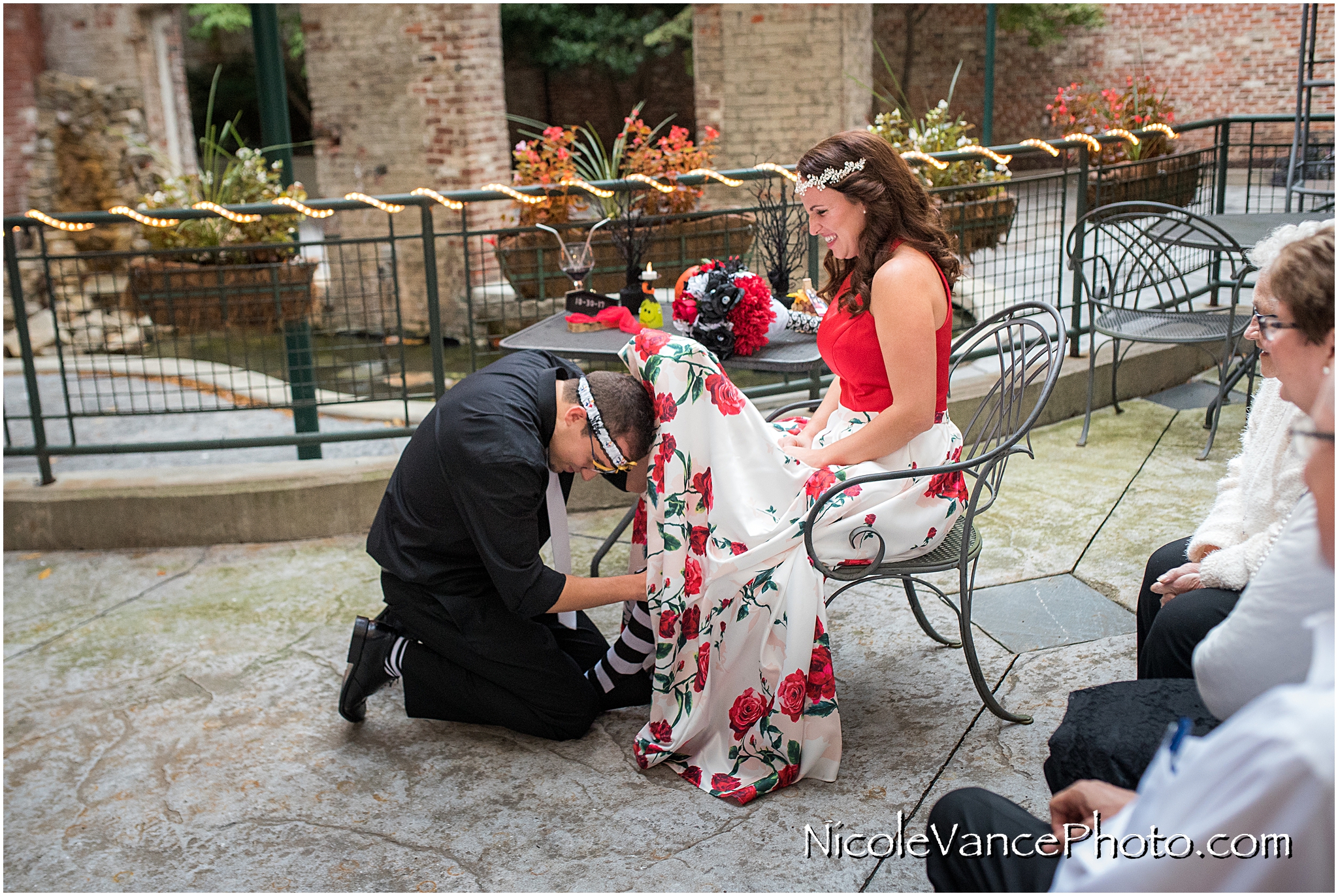 The groom retrieves the garter at Bookbinders on the back patio.