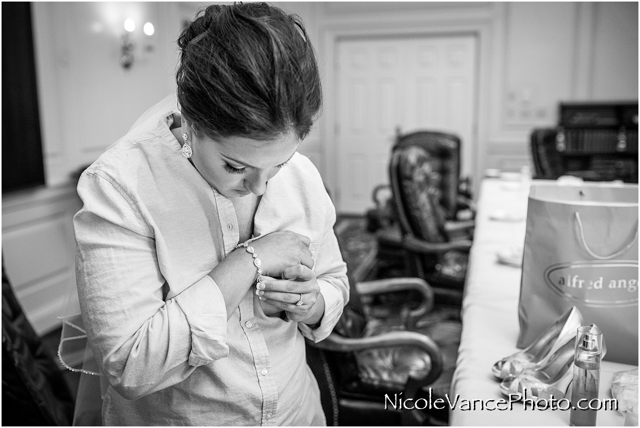 The bride puts on her bracelet in the conference room at Virginia Crossings.