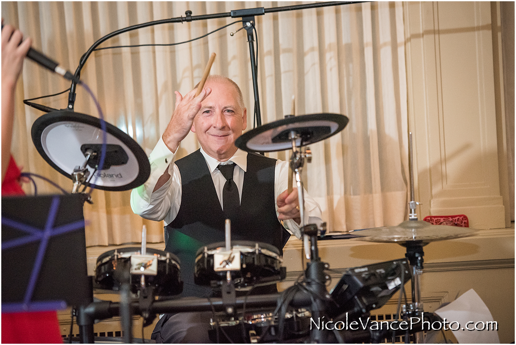 The groom steps in for a drum performance during his wedding reception at the Hotel John Marshall.
