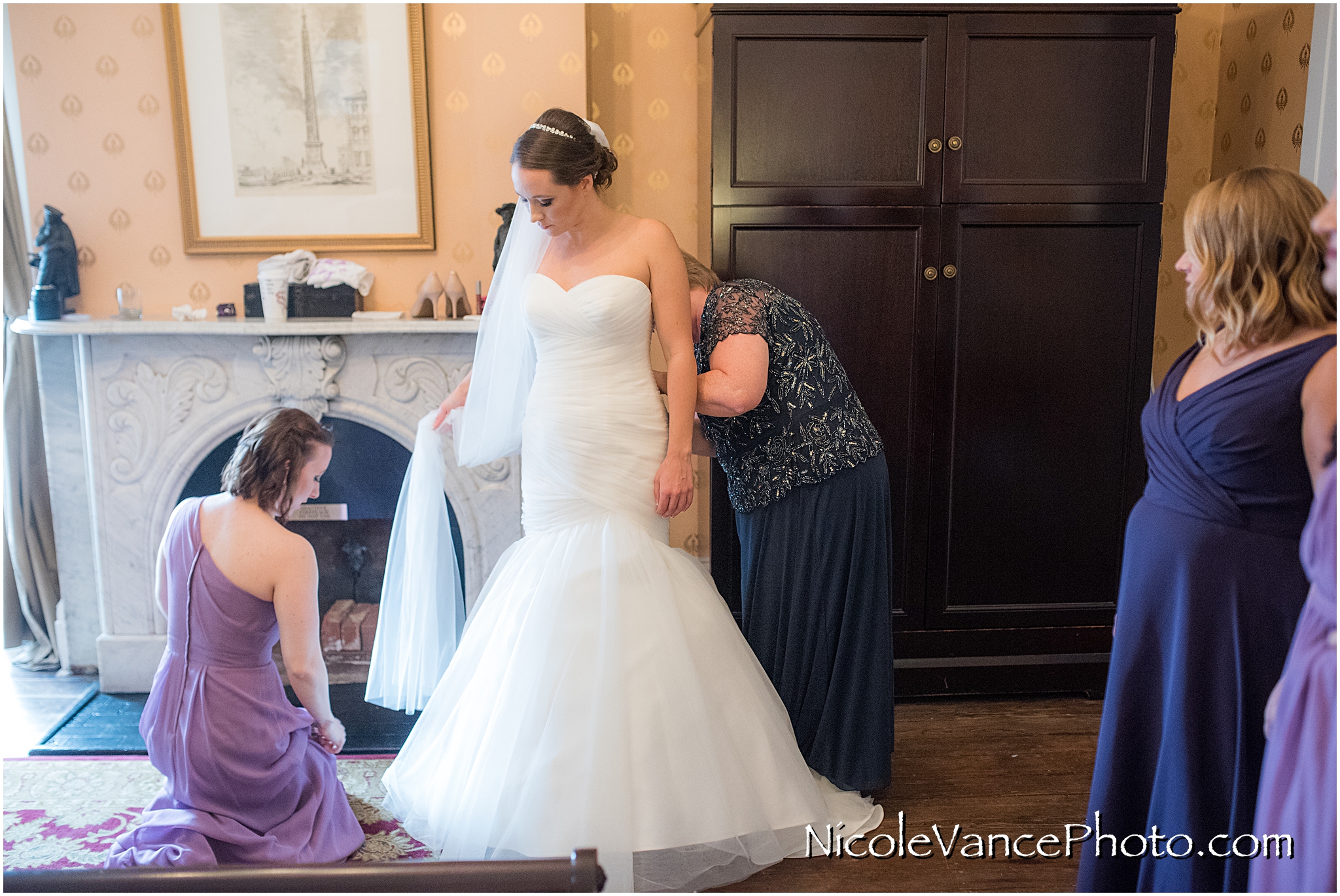 The bride's mom carefully fastens her buttons as she helps her daughter get ready at the Bridal Suite at the Linden Row Inn in Richmond, VA.