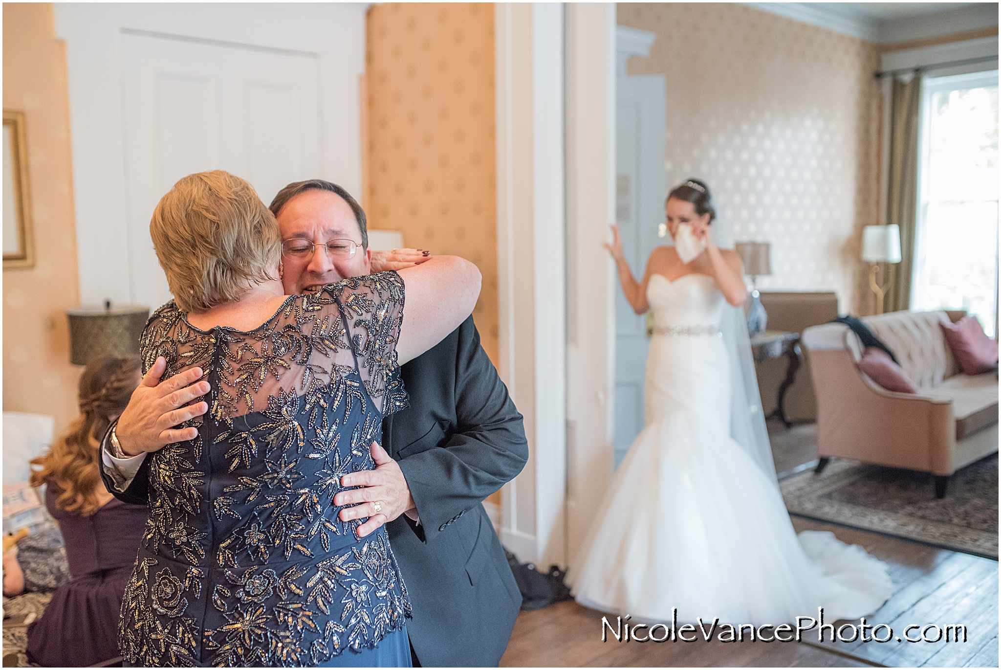 Mom and dad embrace and share a moment together as they share their happiness for their daughter on her wedding day.