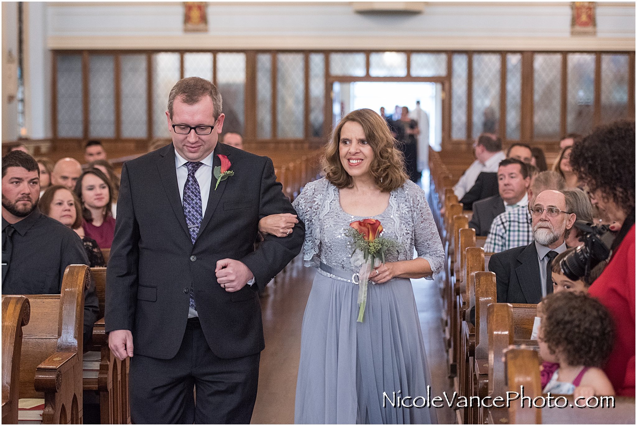 The grooms mom comes down the aisle at St Peter's Catholic Church.