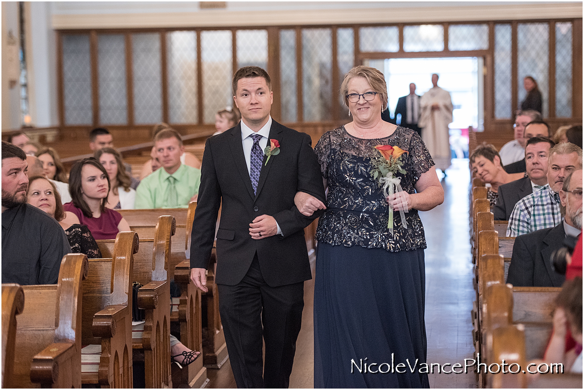 The bride's mom comes down the aisle at St Peter's Catholic Church.