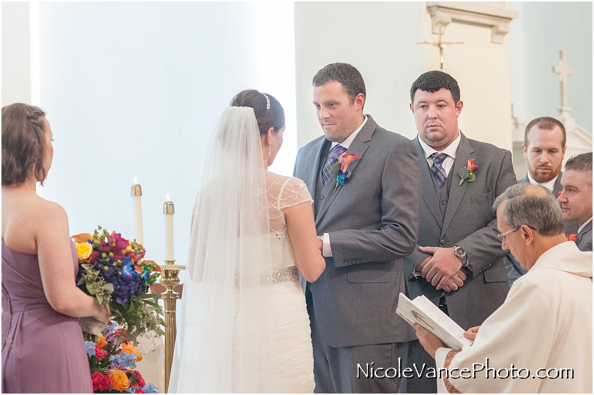 The bride and groom exchange vows and rings during their wedding ceremony at St Peter's Catholic Church in Richmond, VA.