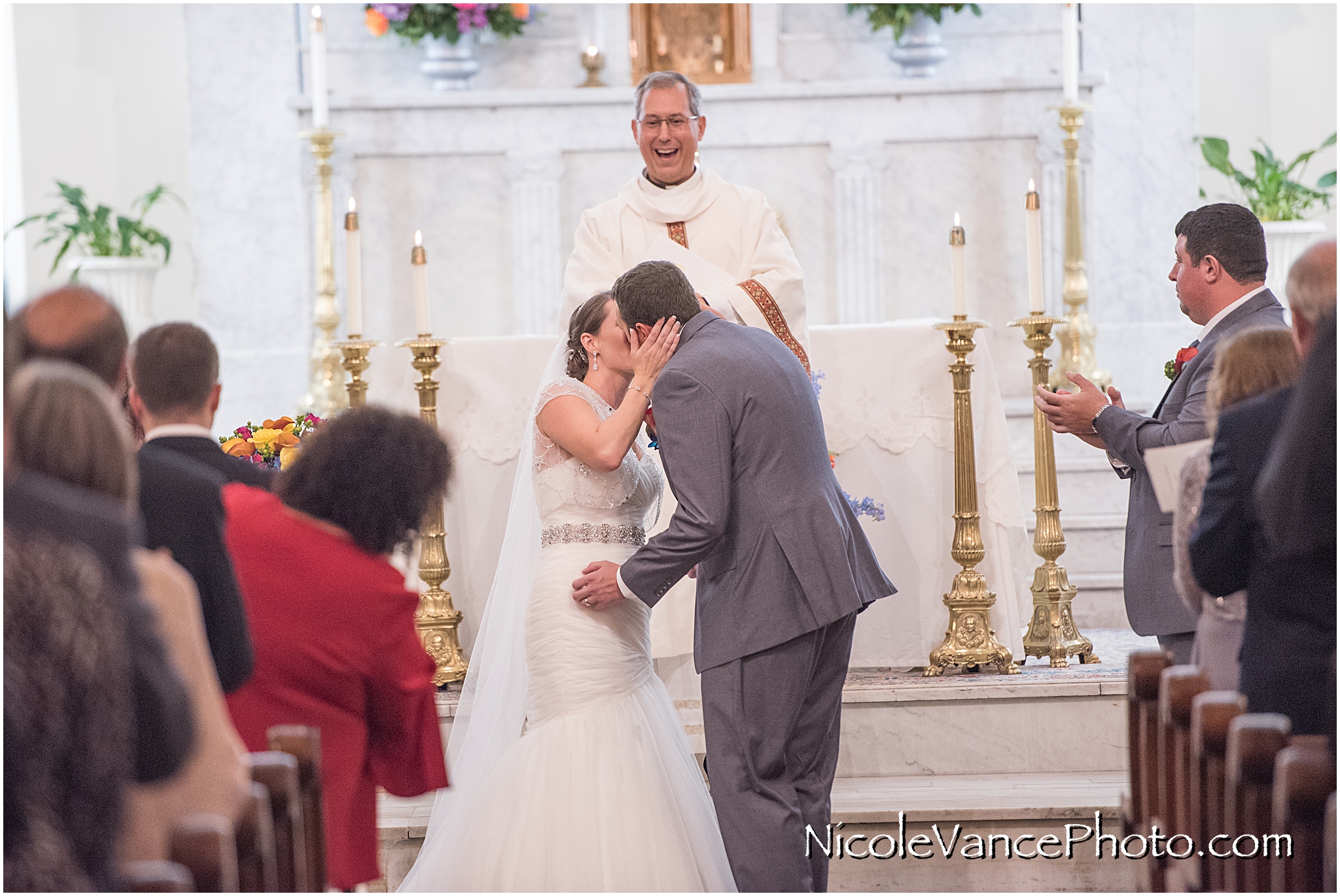 The bride and groom's first kiss during their wedding ceremony at St Peter's Catholic Church in Richmond, VA.