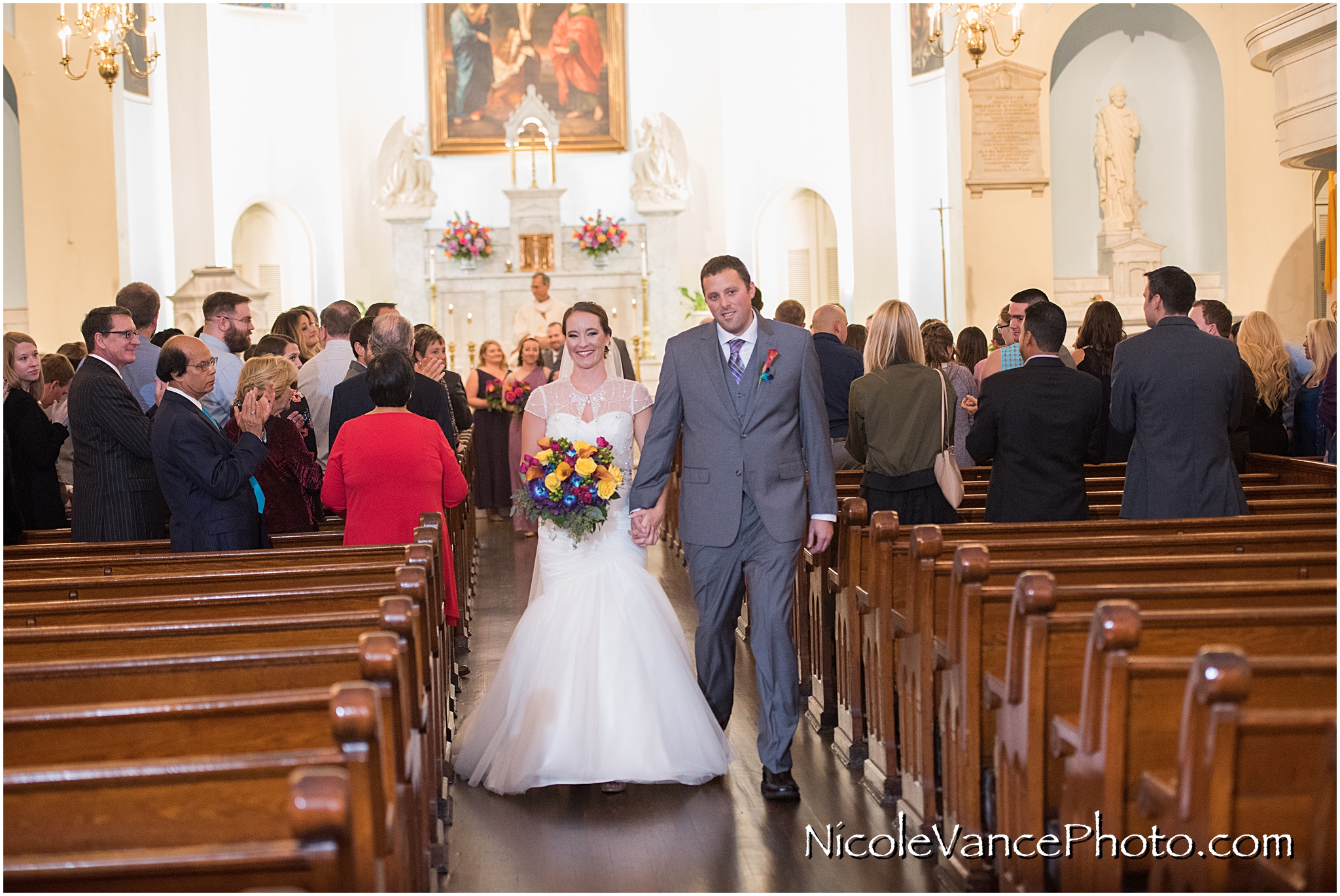 The newlyweds process back down the aisle of St Peter's Church in Richmond VA.