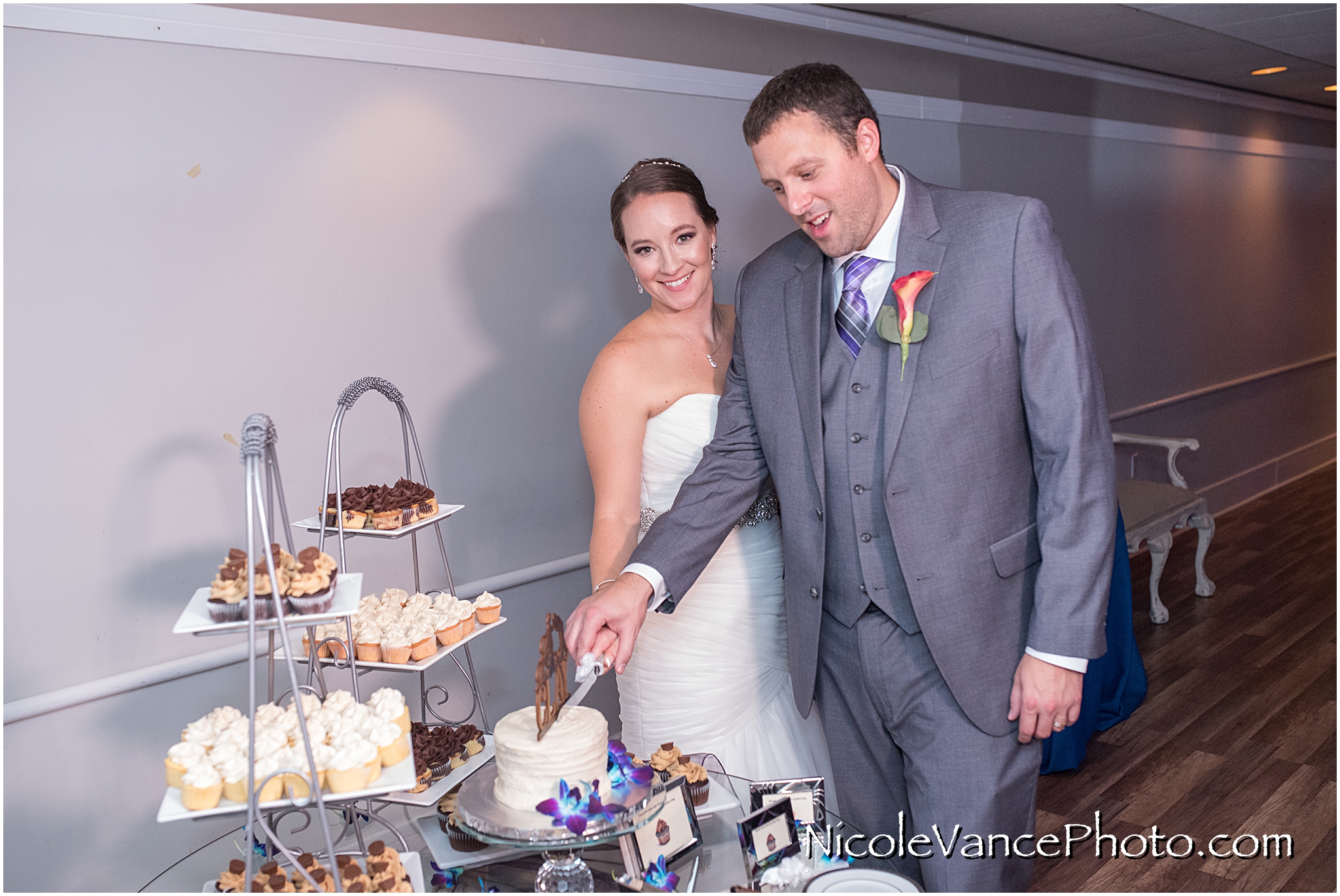 The bride and groom cut their cake, provided by Kakealicious at the reception at The Brownstone.