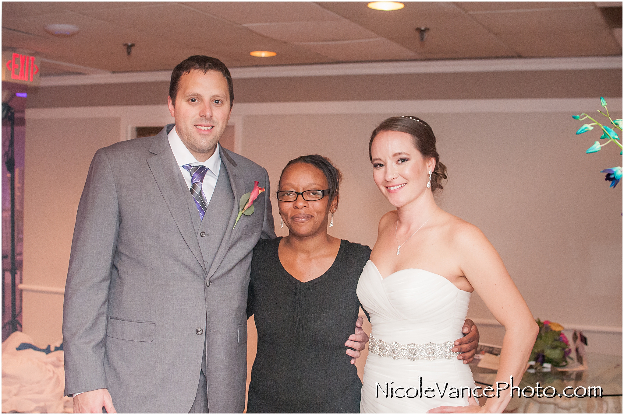 The bride and groom pose with their onsite wedding planner at The Brownstone in Richmond, Virginia.