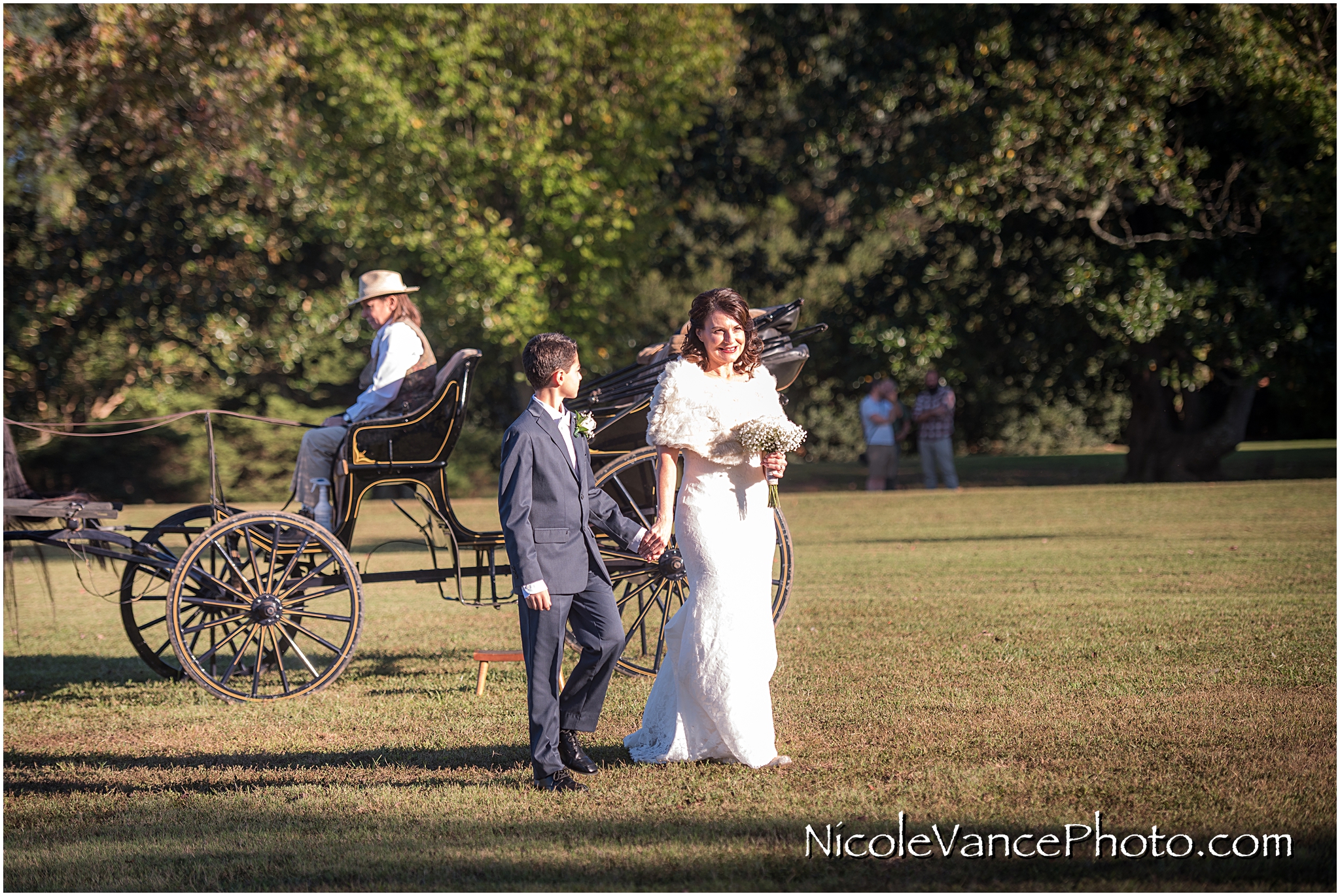 The bride is escorted to the ceremony by her son at Maymont Park.