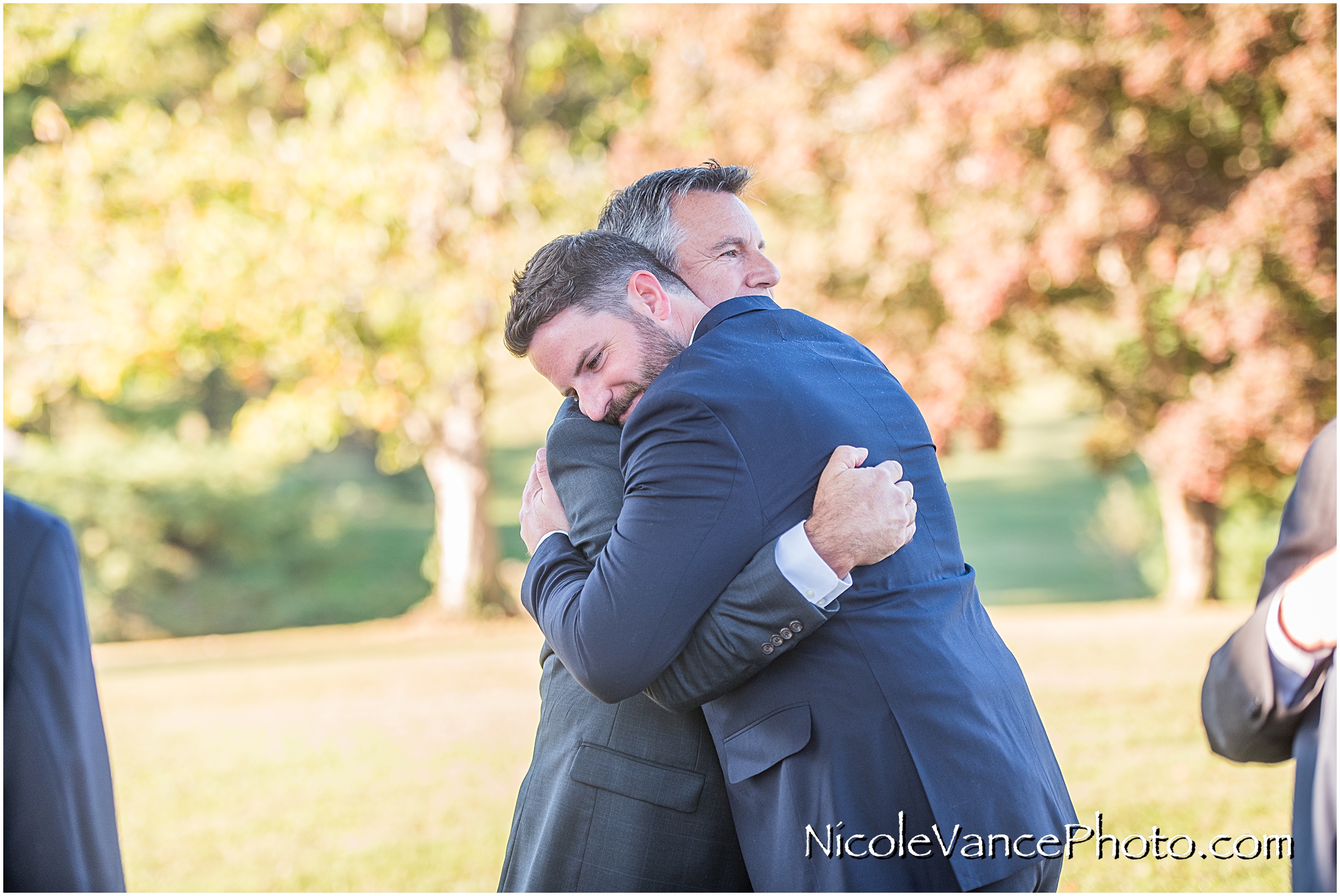 Father and son embrace after the wedding ceremony.